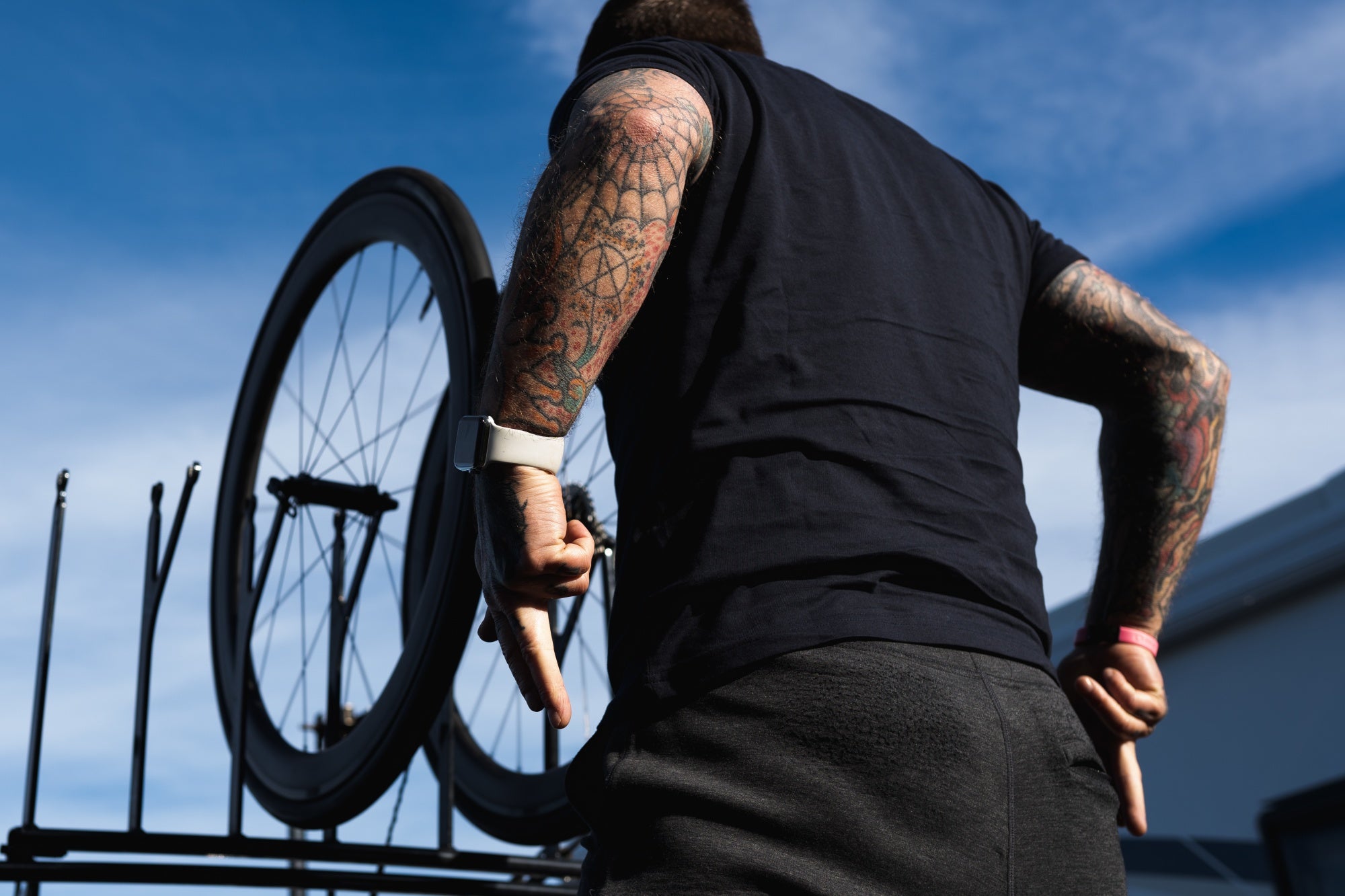 man with tattooed arms making gun fingers