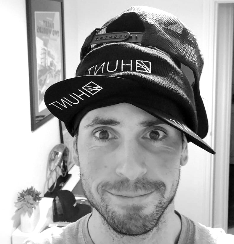 Alex with Hunt hats stacked up high