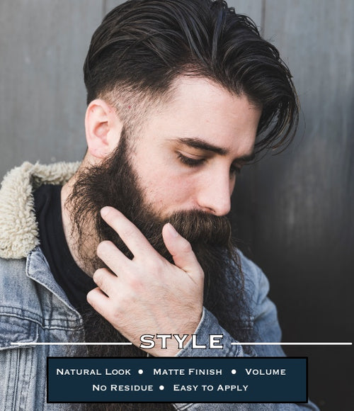 Thoughtful man with a styled, voluminous hair and full beard showcasing a natural look and matte finish achieved with Barber Works Styling Powder, with the words 'STYLE - Natural Look • Matte Finish • Volume • No Residue • Easy to Apply' beneath.