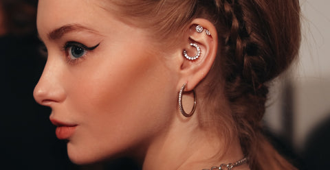 pretty women with ear piercings: earlobe piercing, daith piercing and conch piercing