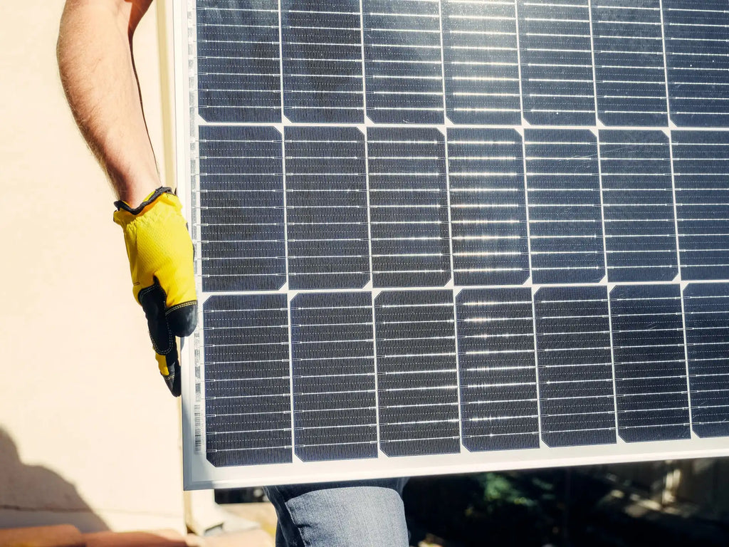 Ein Mann trägt ein Solarpanel in kleiner Größe