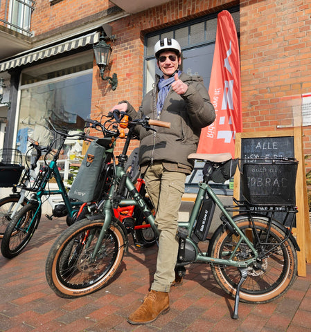 Paddy mit seinem i:SY e-Bike vor unserem i:SY Laden mit Begrüßung