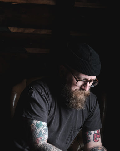 Man with tattoo wearing Black Watch Cap