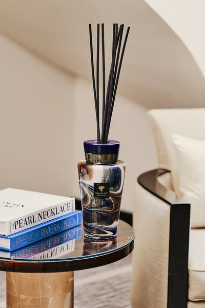 Baobab Delta Nil Totem diffuser with reed diffuser sticks styled on a side table with coffee table books