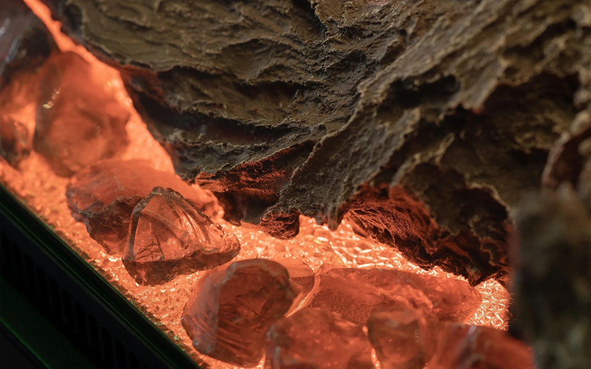 A close up of the Planika Electric LED Astro Wall Mounted fireplace with rocks and logs, showcasing its design flexibility.