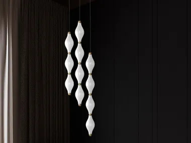 Minimalist vertical interconnected glass pendants against a dark backdrop, highlighting modern monochrome trends in stairwell lighting from Spacio’s 2025 design edit.