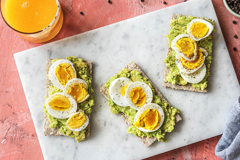 Hardgekookte eieren met fruit en crackers.