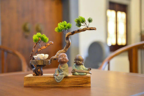 A tea pet figurine in the image of 2 monks.