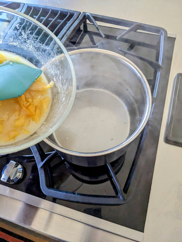 Adding oleo-saccharum to boiled water off heat