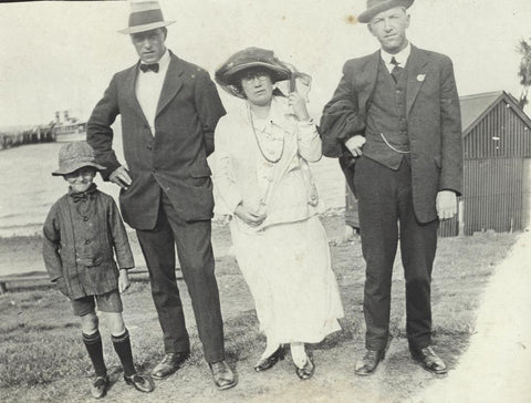 Une ancienne image datant de 1900 où l'on voit une famille avec un enfant portant un bob