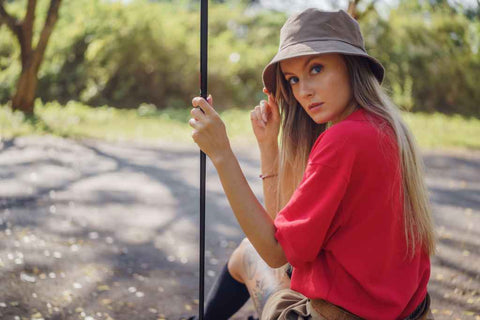 Une femme assise par terre porte un bob réversible.