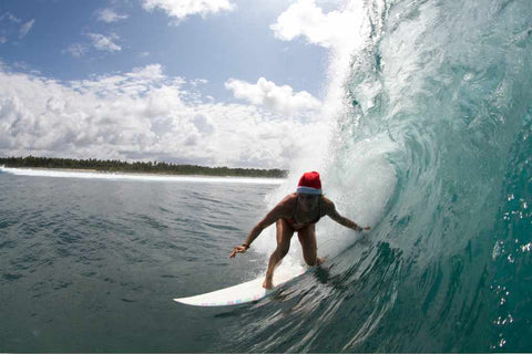 Une femme Surf en portant un chapeau de noël.