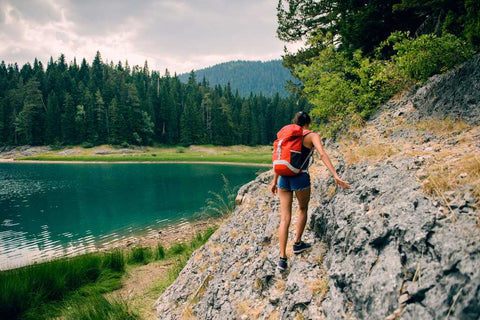 Montagne, lac et une femme qui fait de la randonnée.
