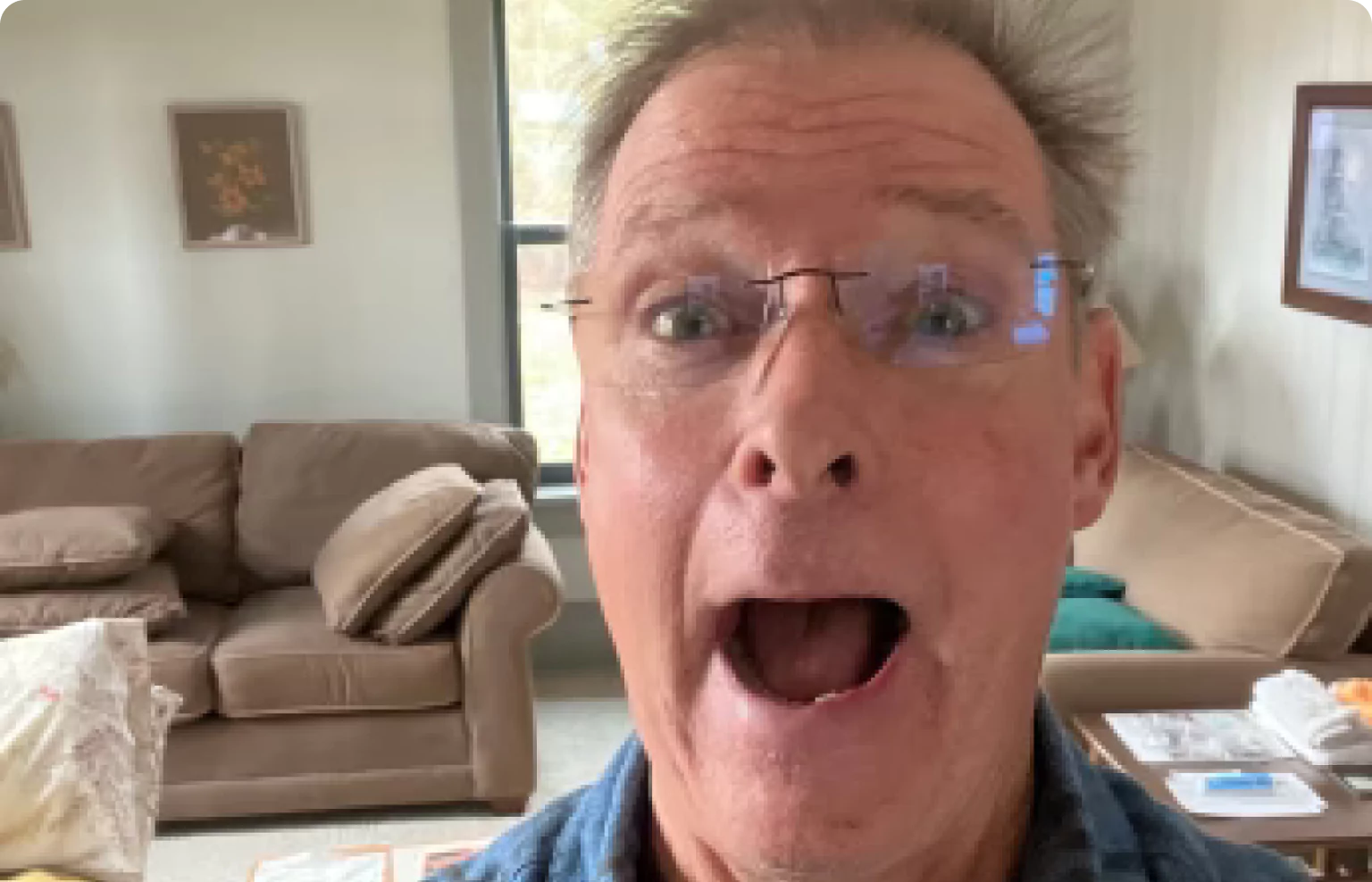 Person making a surprised facial expression in a living room.