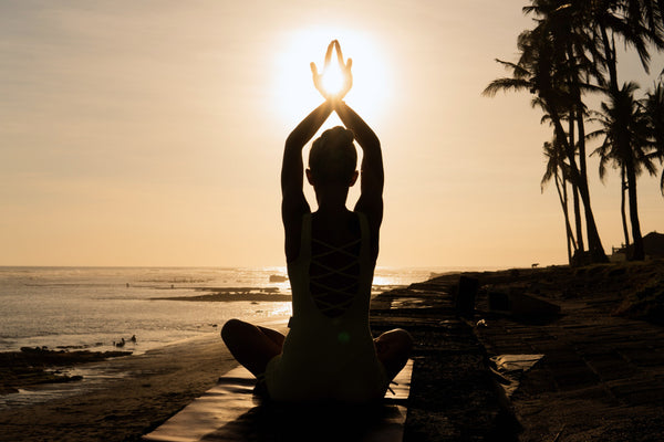 Silhouette of a woman meditating on a beach