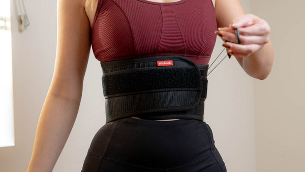 A woman tightening a back brace
