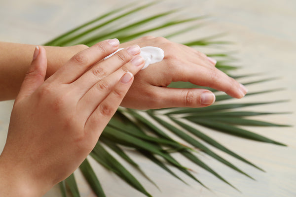 A hand placing pain relief cream on