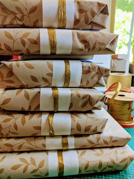 A pile of gifts wrapped in kraft eco-wrapping paper with paper ribbons