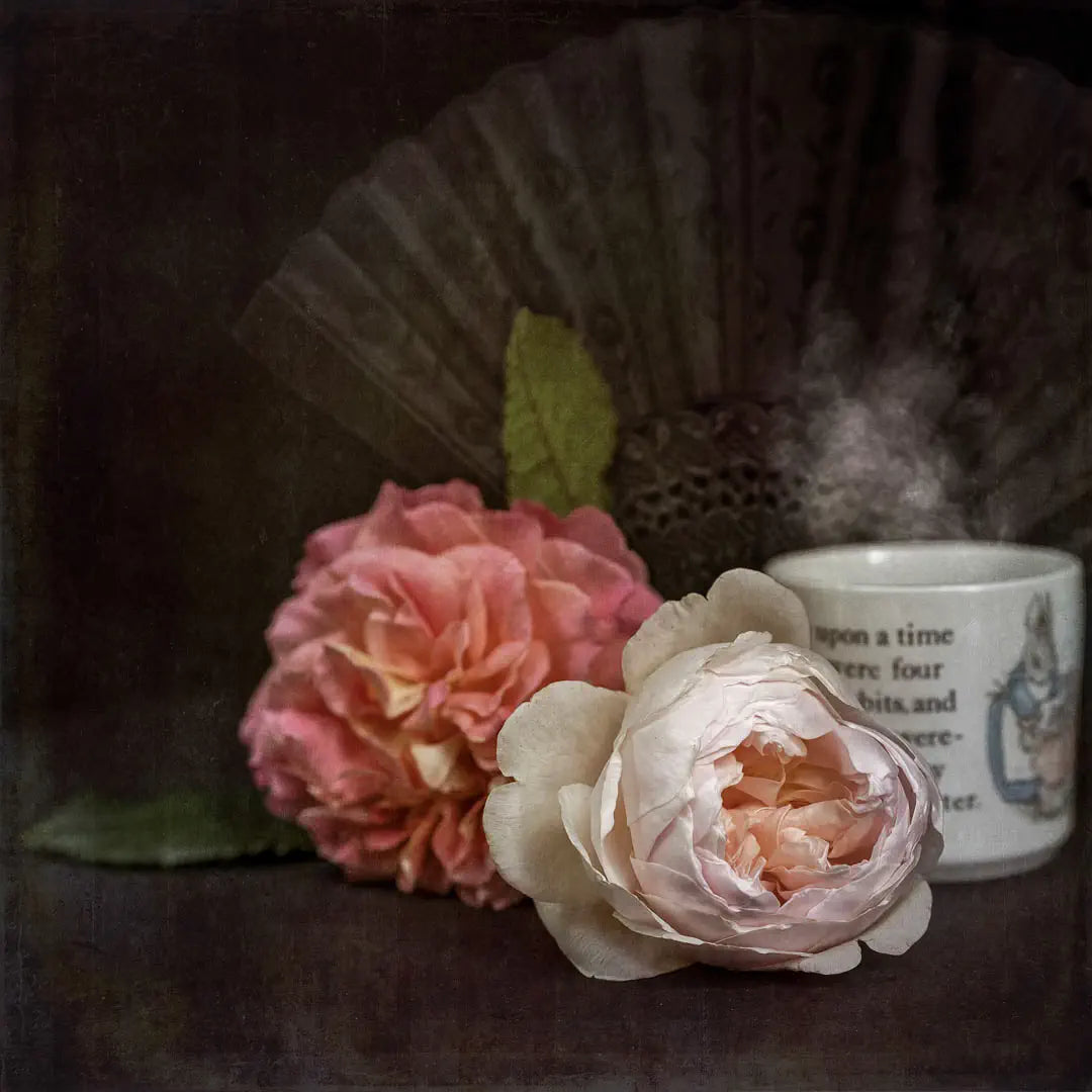 Still life photo-art of roses, a fan, and a steaming mug