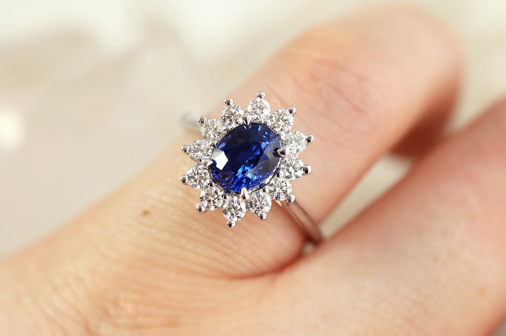 white gold engagement ring featuring oval Ceylon Sapphire and white diamond halo