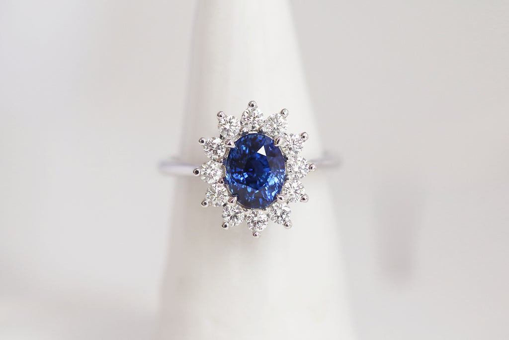 white gold engagement ring featuring oval Ceylon Sapphire and white diamond halo