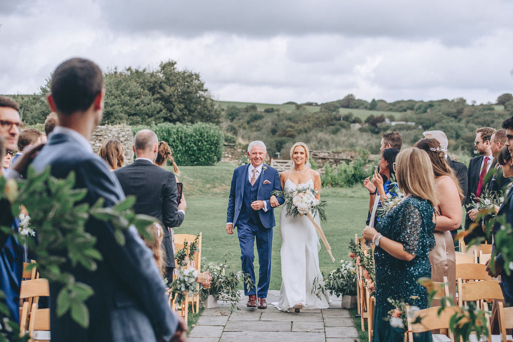Bride and father walking down aisle Trevenna barns