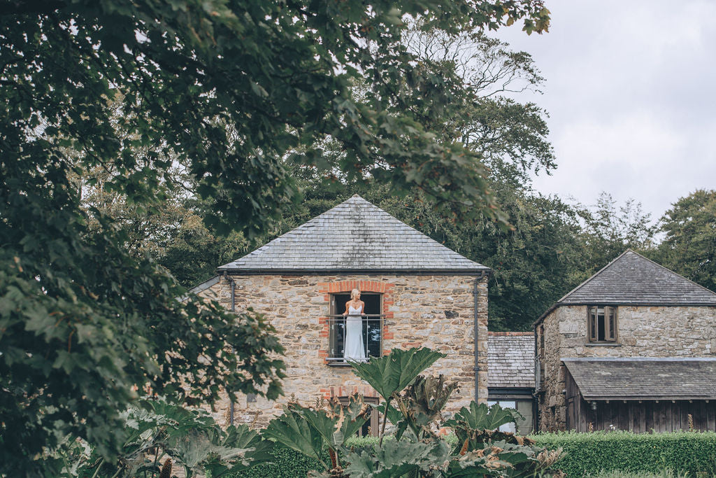 Bride on barn balcony Trevenna wedding