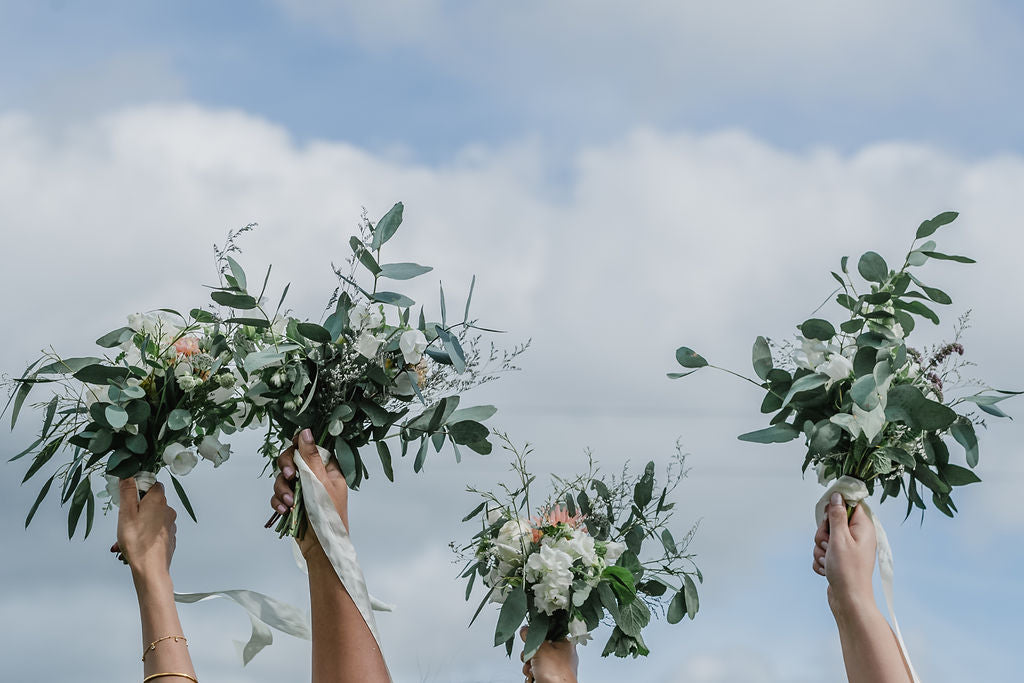 Bouquets held in the air at Trevenna barns