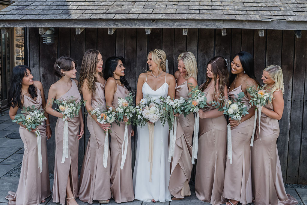 Bridal party in front of wooden wall at Trevenna barns