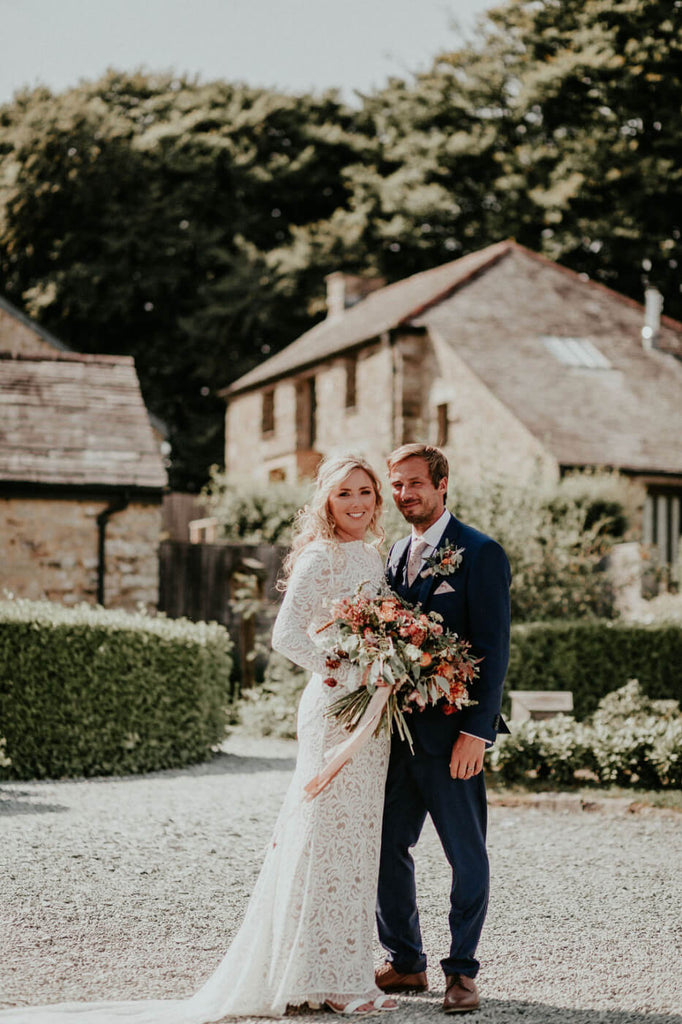 Claire & Joe in front of the barns Trevenna wedding
