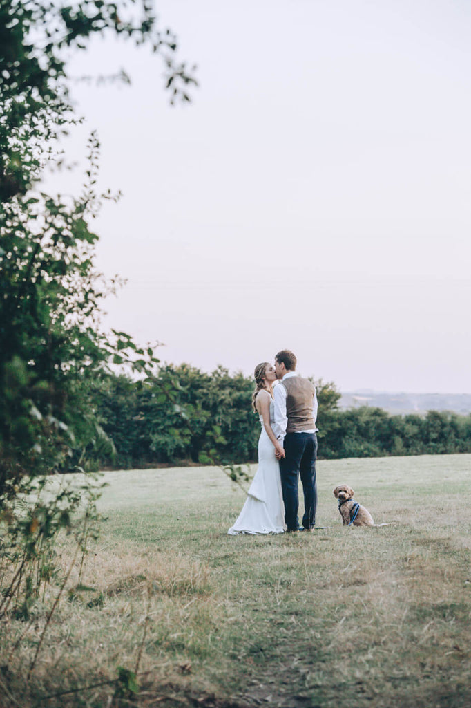 Dog with bride and groom kissing