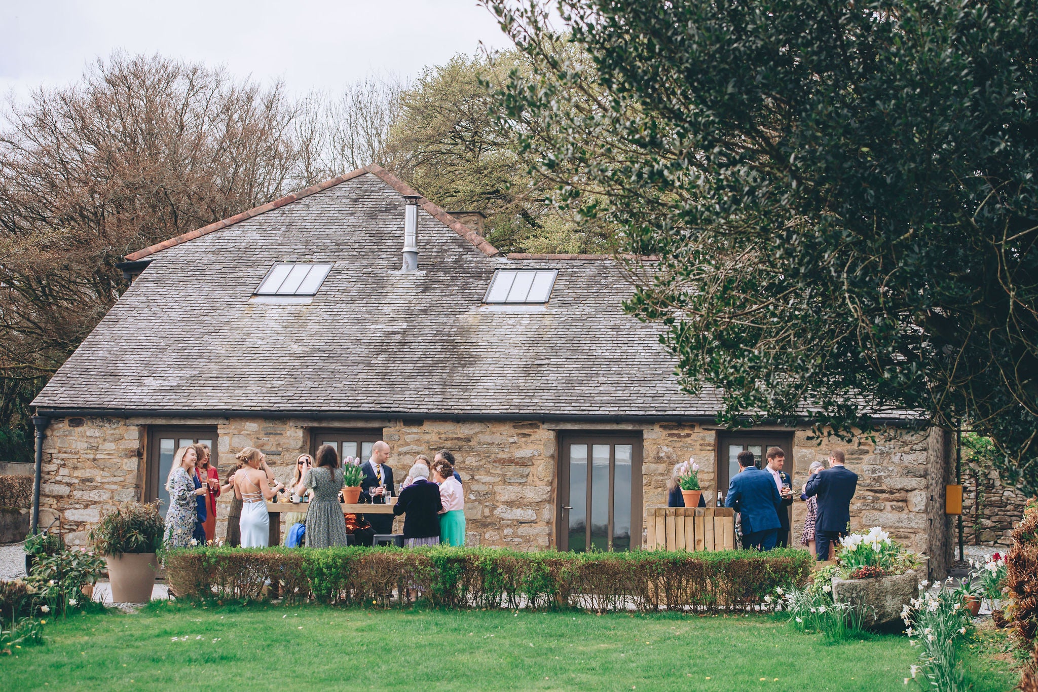 Guests gathering for drinks at Trevenna wedding barns