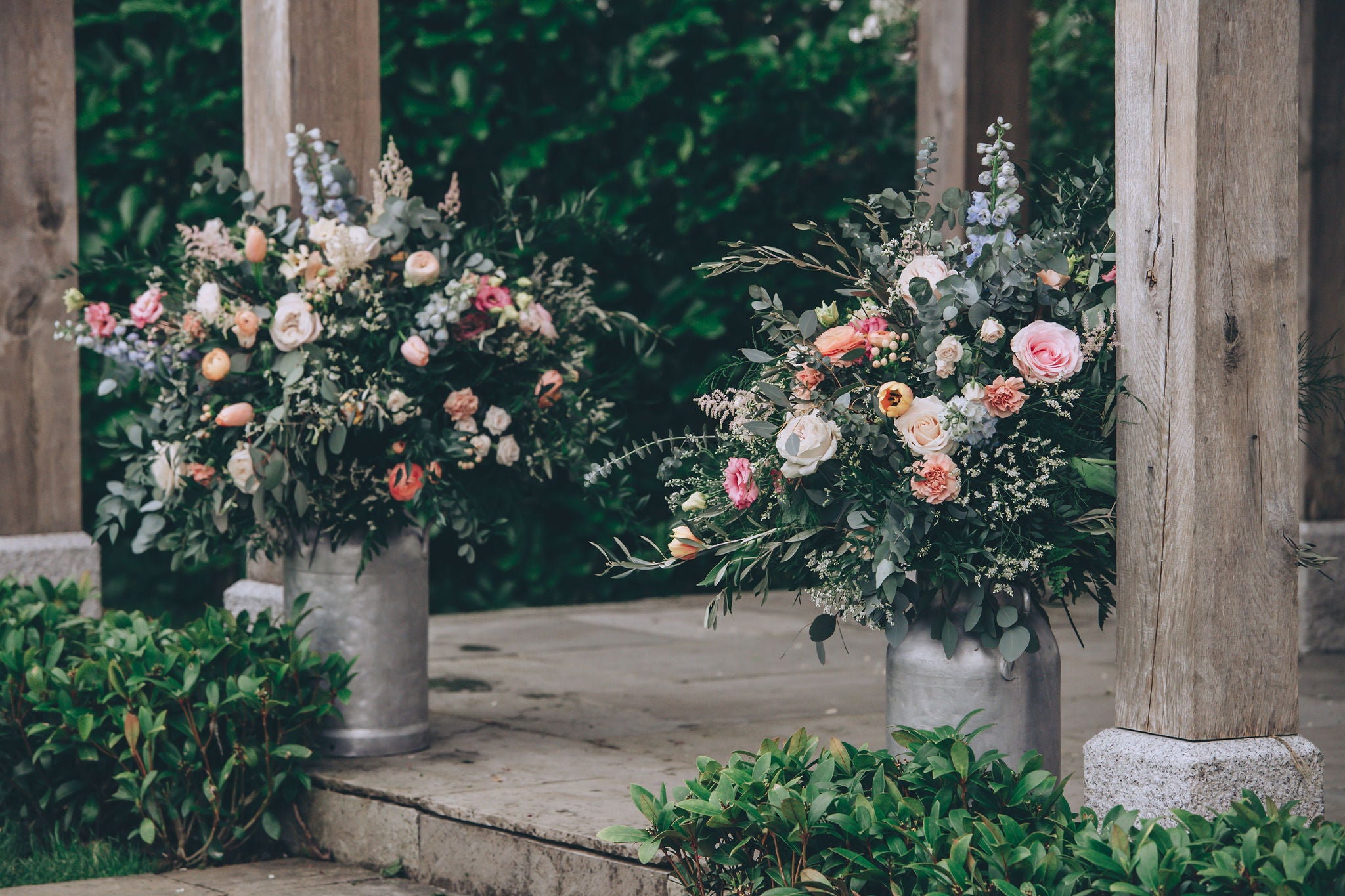 Two milk churns decorated with flowers at Trevenna wedding barns