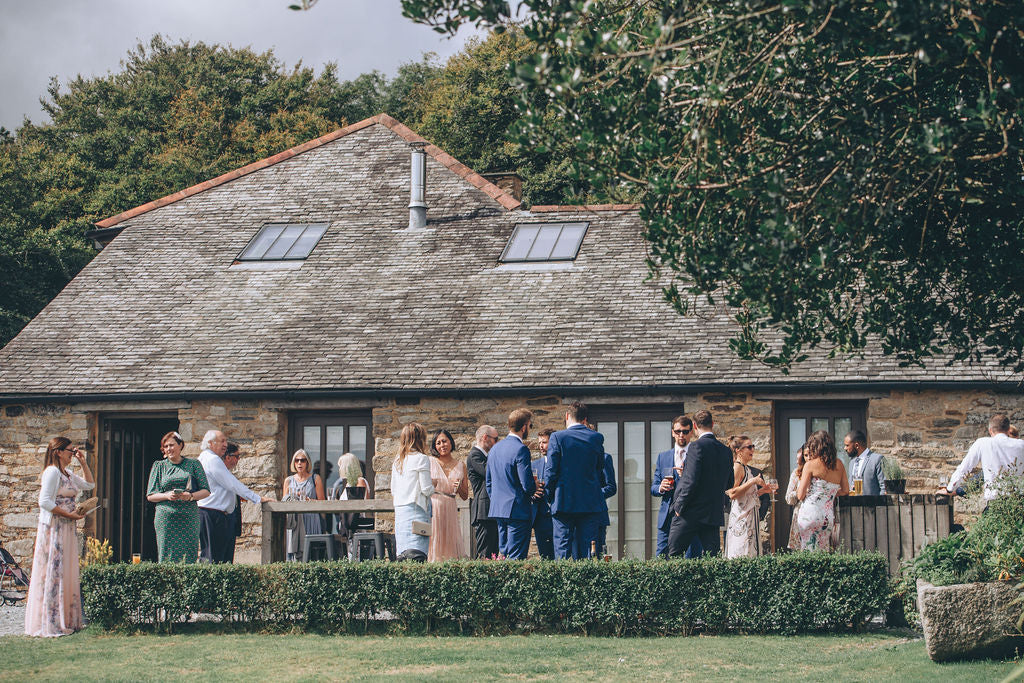 Wedding drinks outside barns at Trevenna