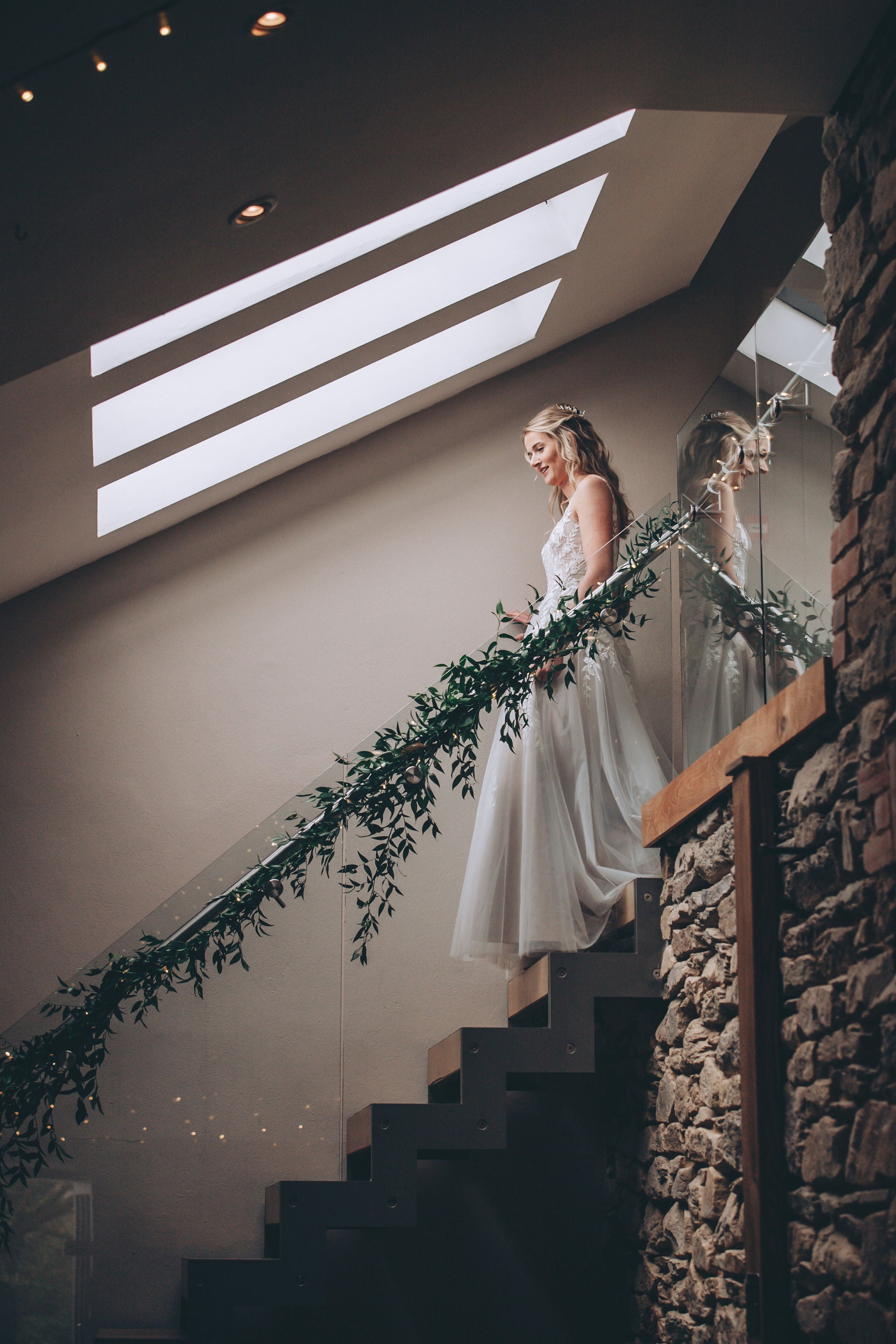 Bride walking down glass stairs at Trevenna barns