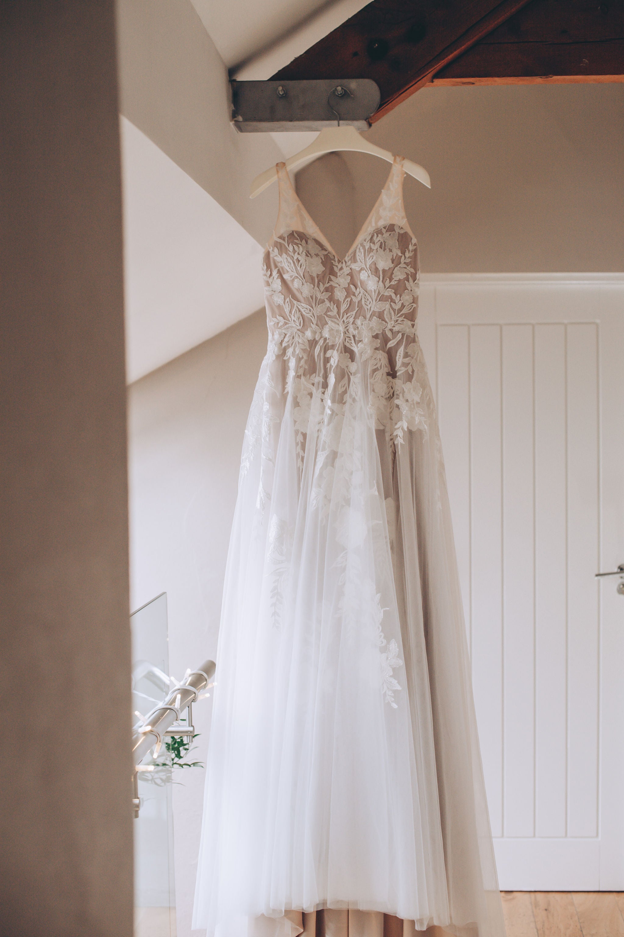 Wedding dress hanging from beam at Trevenna wedding barns