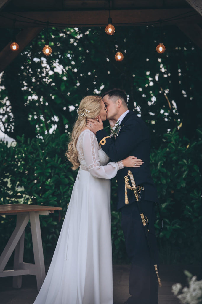 bride and groom kiss outside ceremony