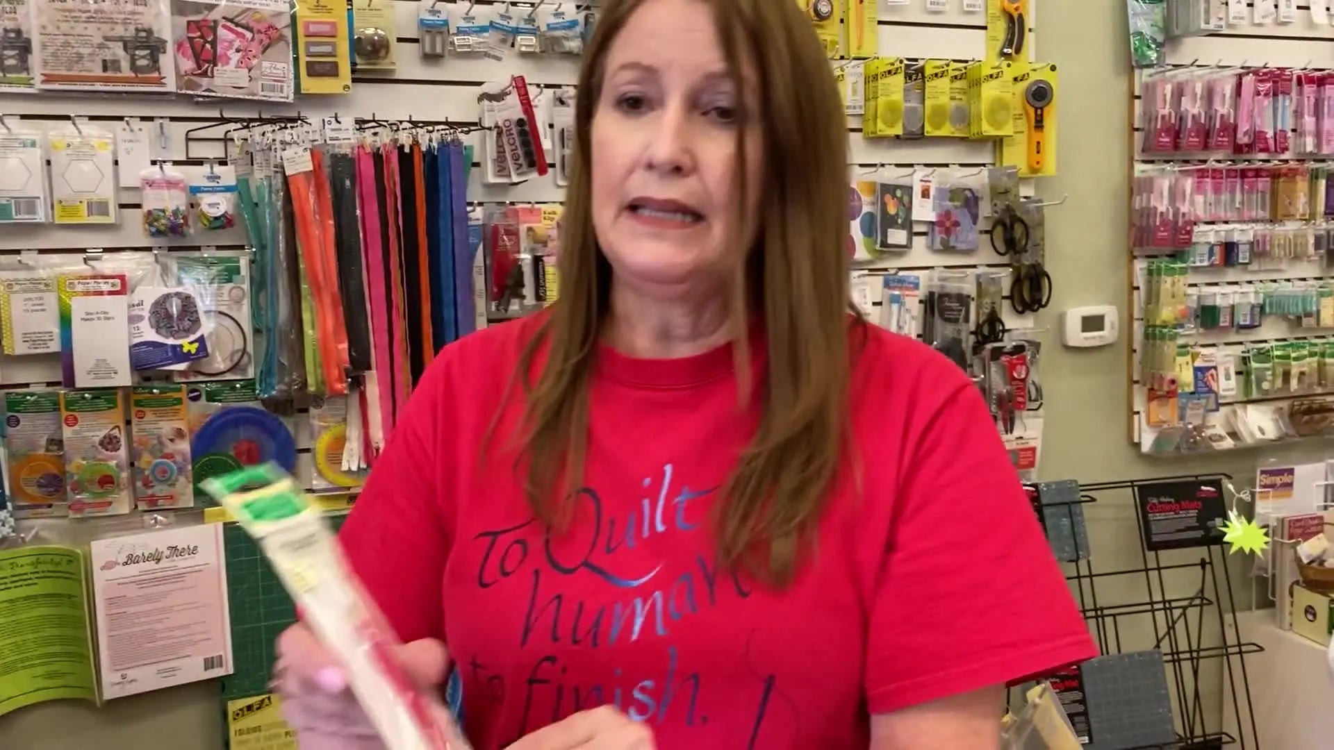 A red iron-on transfer pencil in its clear plastic packaging, labeled 'PICK-N-TRACER PENCIL by Clover'.