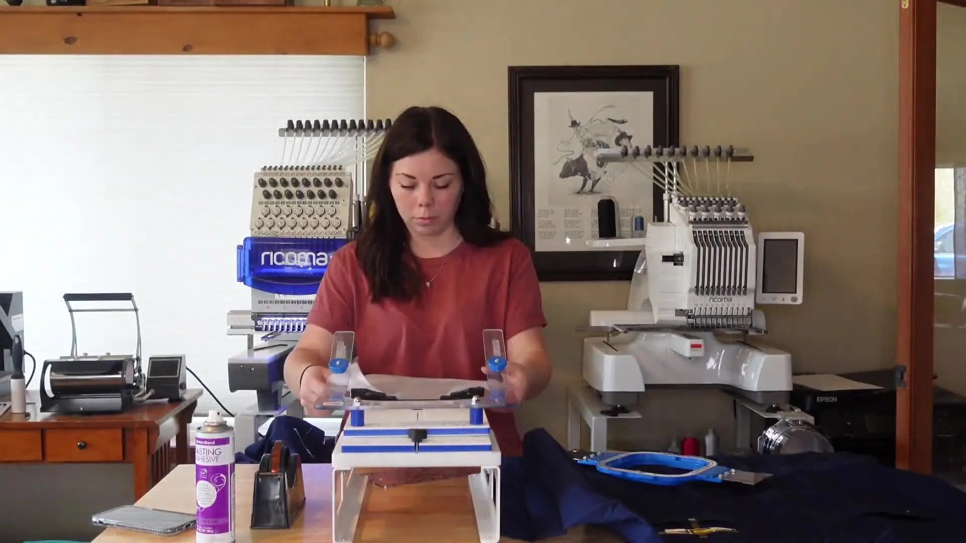 Woman hooping a navy blue t-shirt onto an embroidery frame using a hooping station.