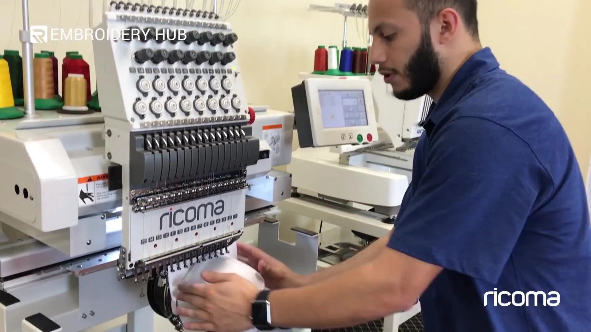 Hands hooping a white cap onto the cap driver, facing forward.