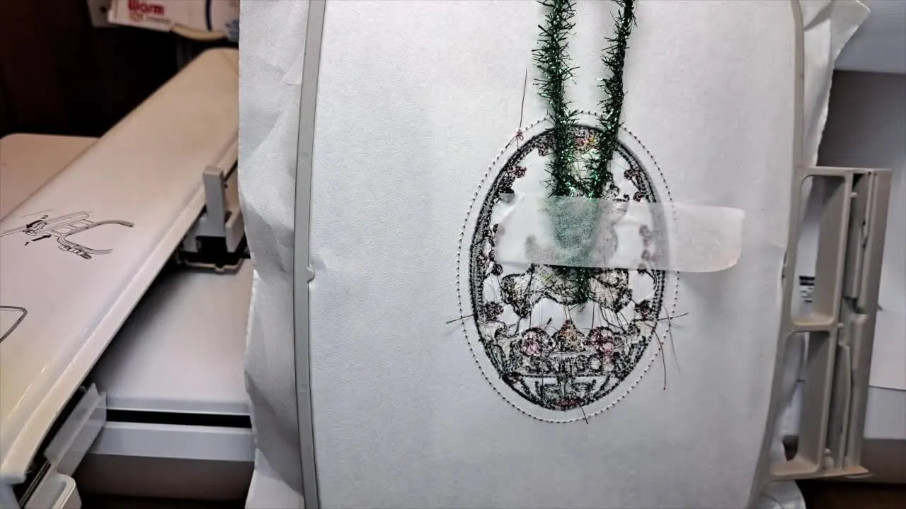 Hand placing a piece of sparkly white felt over the stitched oval placement line