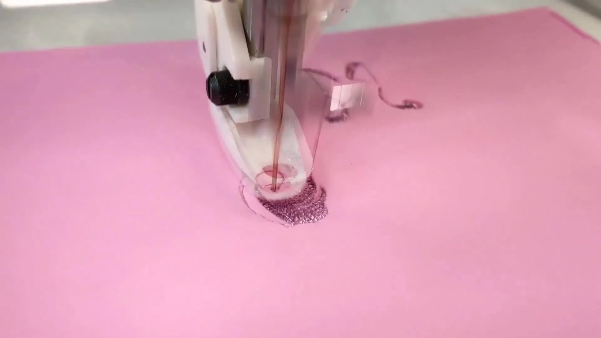 Embroidery machine stitching over the pink puff foam, covering it completely.