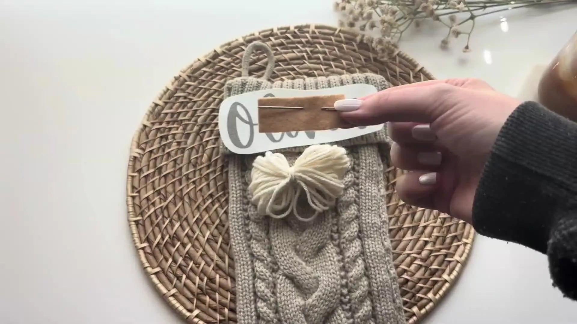 A darning needle held between fingers.