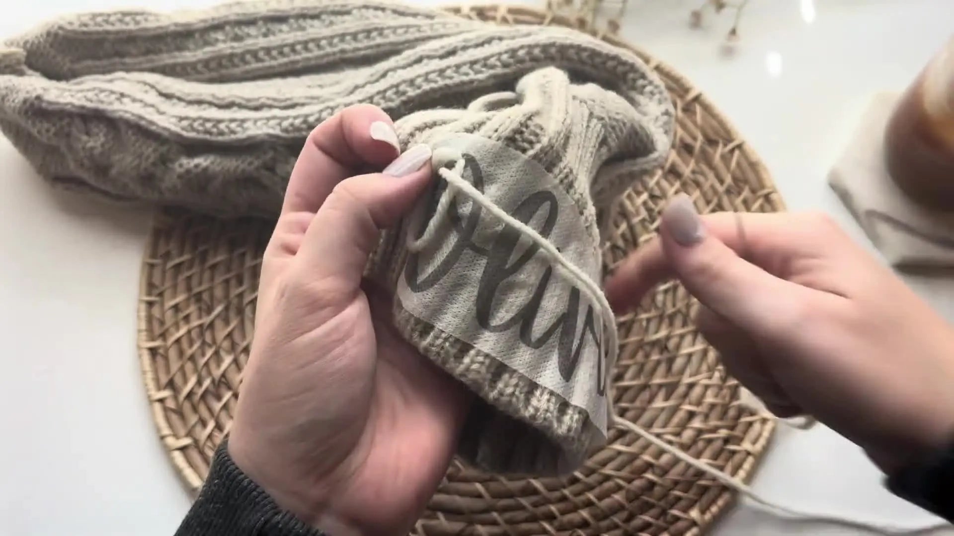 Needle pulled through a loop to catch a chain stitch.