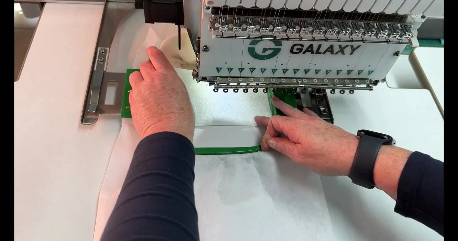 Hands pressing vinyl into the embroidery hoop