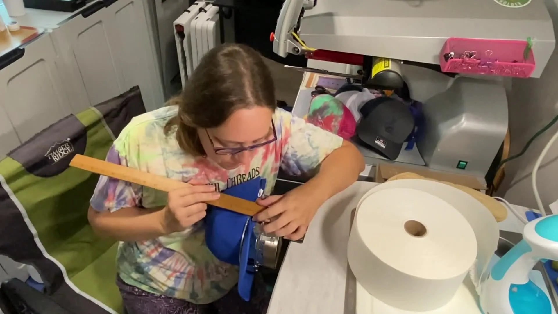 A wooden ruler measuring the distance from the metal hoop frame to the side of the hat.
