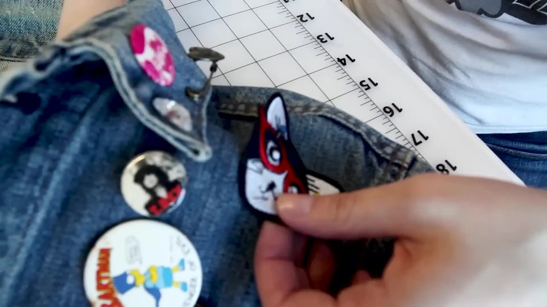 Thimbled finger guiding the needle through the patch, ready to pull the thread.