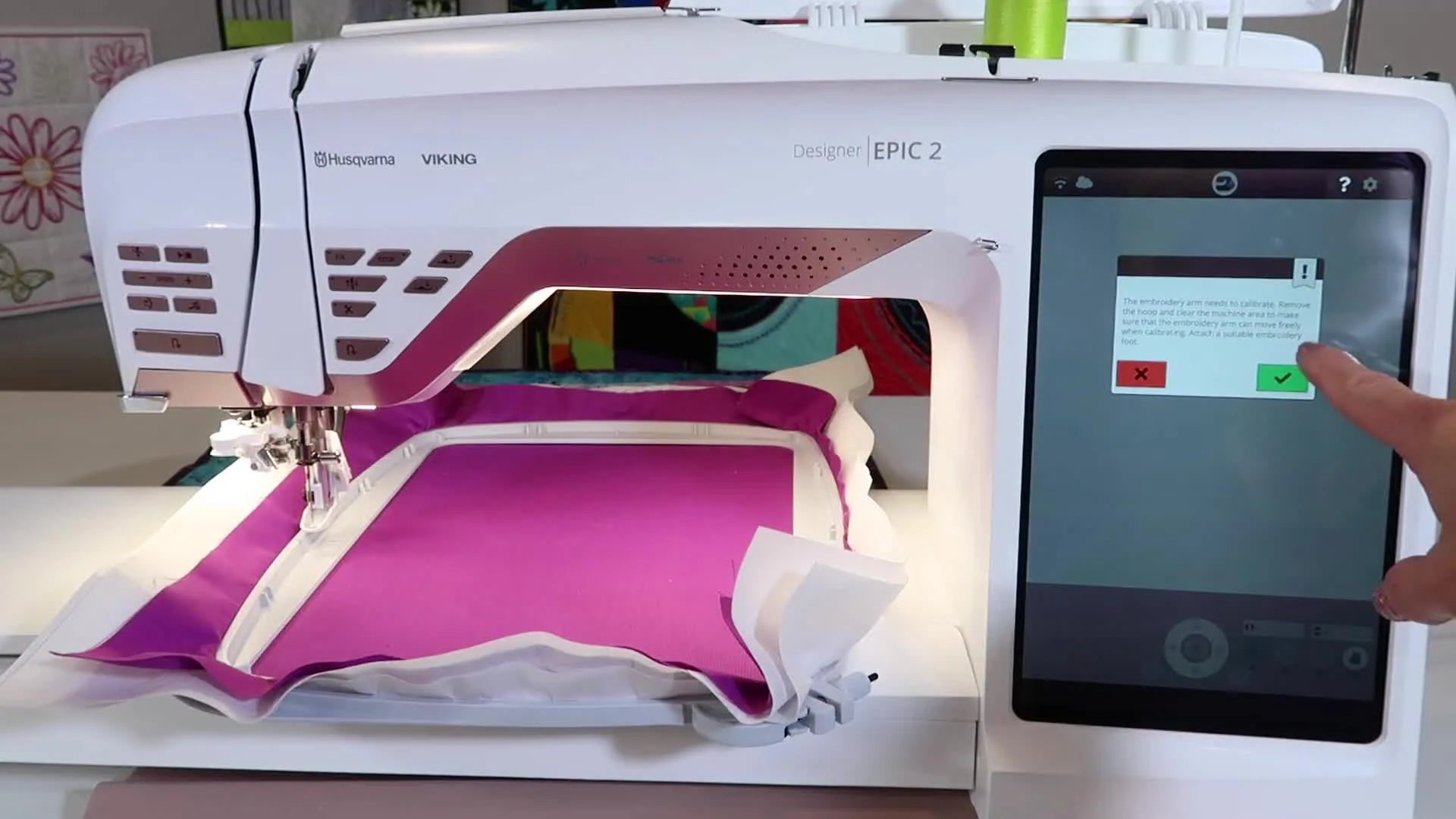 Machine screen displaying a message about the embroidery arm needing calibration and advising to remove the hoop.