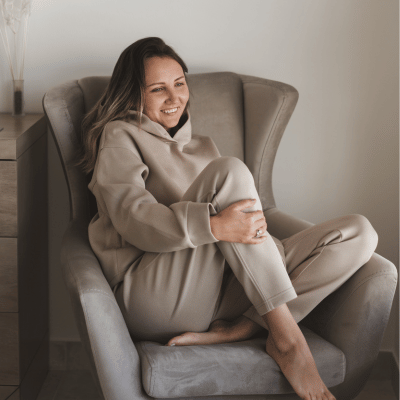 This image shows a woman sitting on a couch feeling relaxed