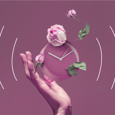 The image shows a person holding a flower and a clock.